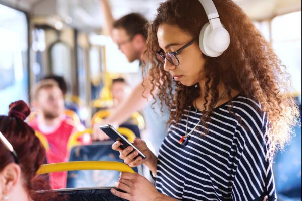 A woman listening to her headphones on public trnasport
