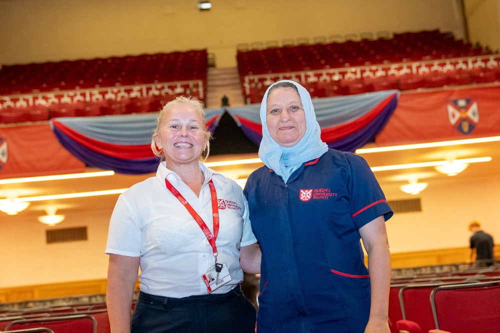 two women smiling to camera in a large hall