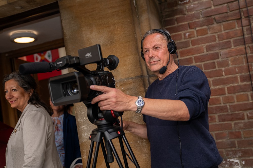 mature man operating a video camera in an enclosed outdoor space