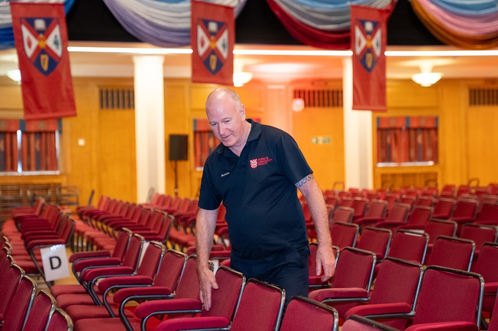 man in a large event hall checking seating alignment or arrangements