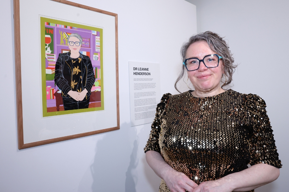Nominee Leanne Henderson standing in front of her portrait in the Naughton Gallery