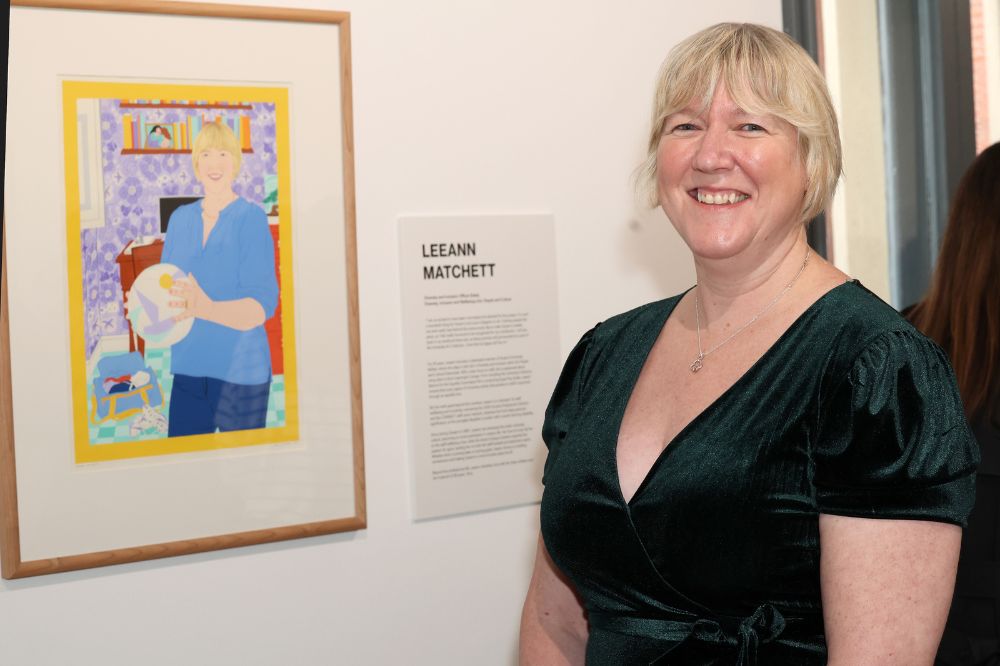 Nominee Leeann Matchett standing in front of her portrait in the Naughton Gallery
