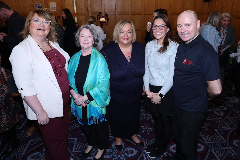 A group of QUB Staff mingling at the Portrait Illustration Project Event
