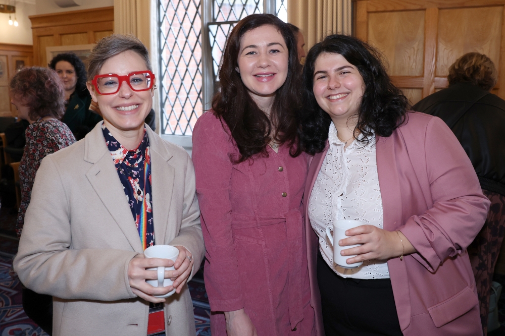 Three smiling ladies in attendance at the Portrait Illustration Project event.