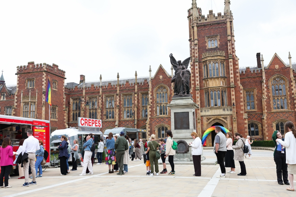 queue of people waiting to purchase food at food trucks on the concourse of Queens University Belfast