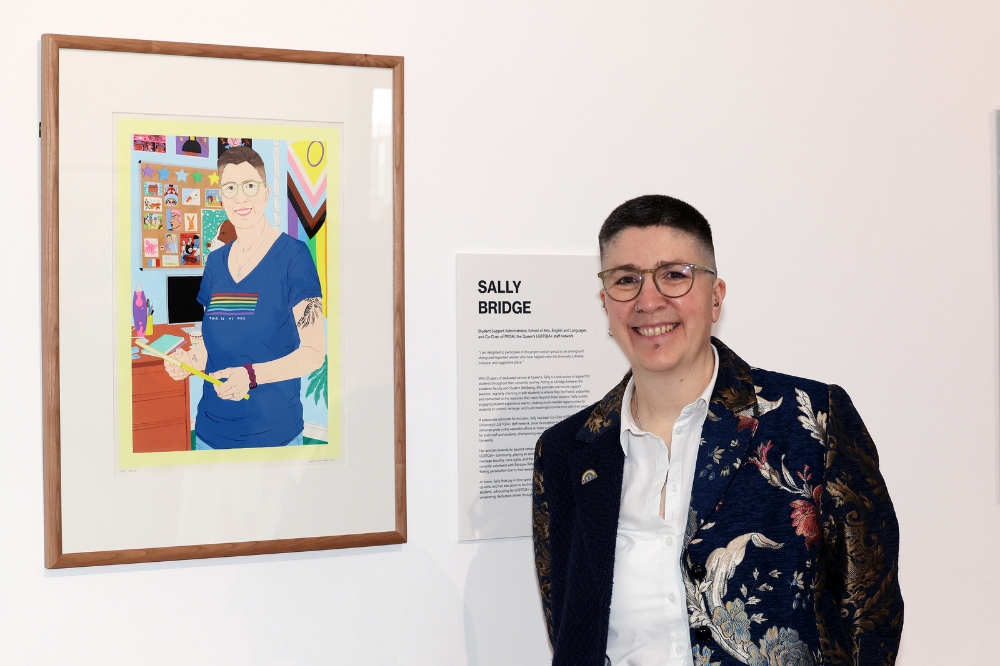 Nominee Sally Bridge standing in front of her portrait in the Naughton Gallery