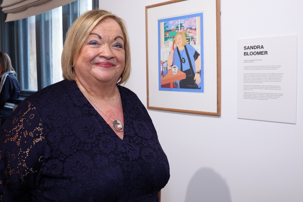 Nominee Sandra Bloomer standing in front of her portrait in the Naughton Gallery