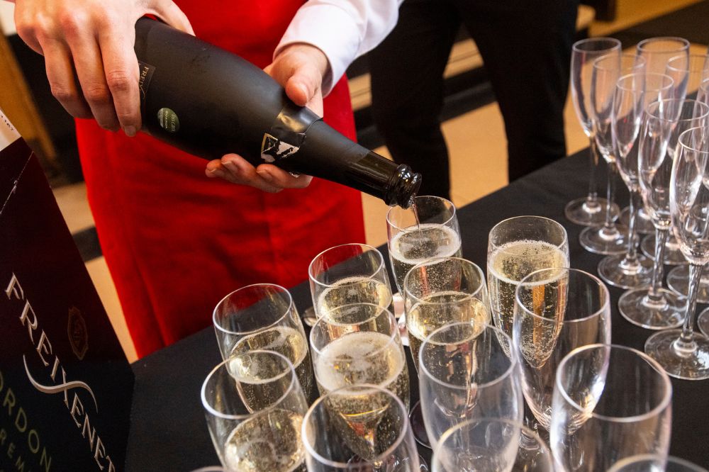 catering personnel pouring glasses of Prosecco into champagne flutes