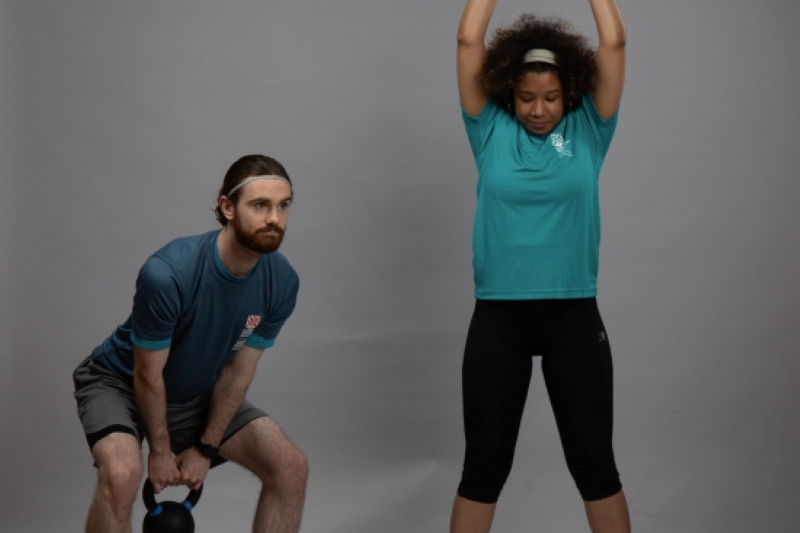 man and woman strength training with dumbells